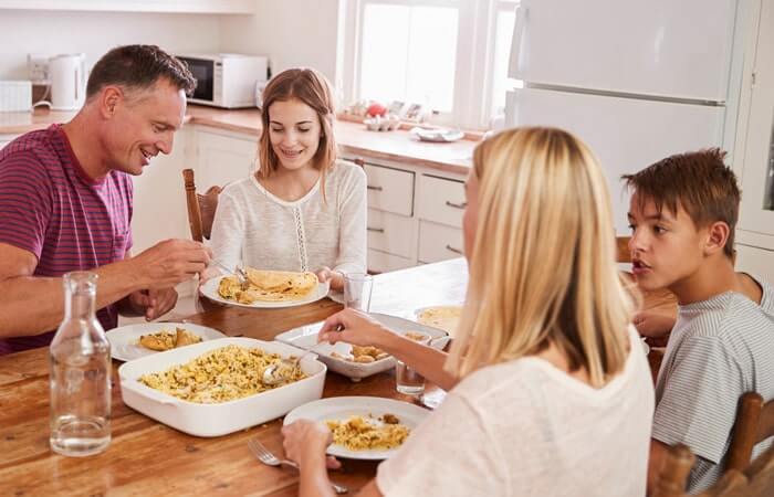 Host family with English students eating dinner